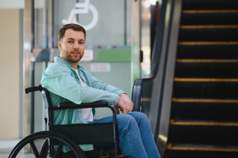 Man in wheelchair facing accessibility issues in shopping mall with escalator in background